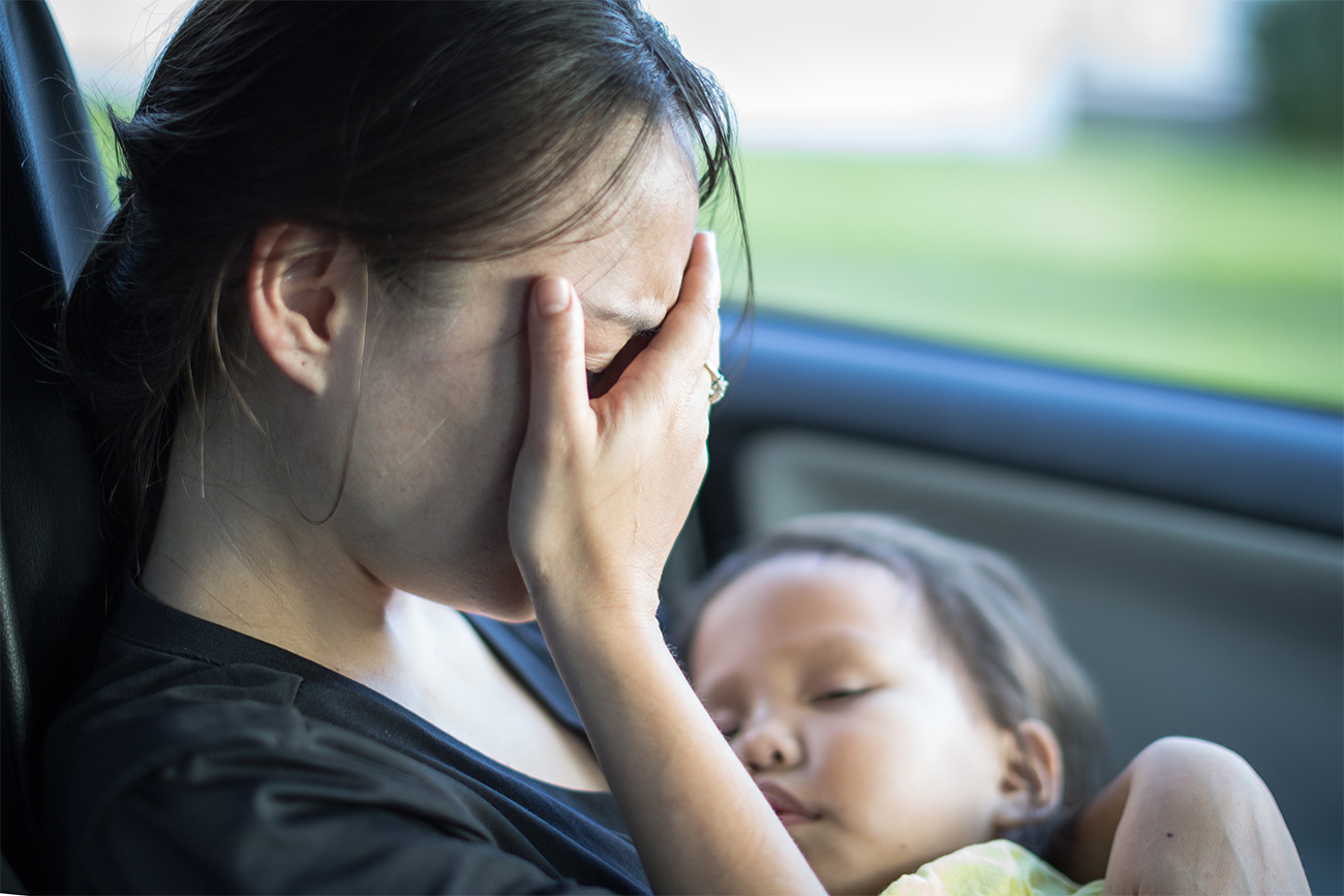 Frau sitzt mit Kind im Auto.